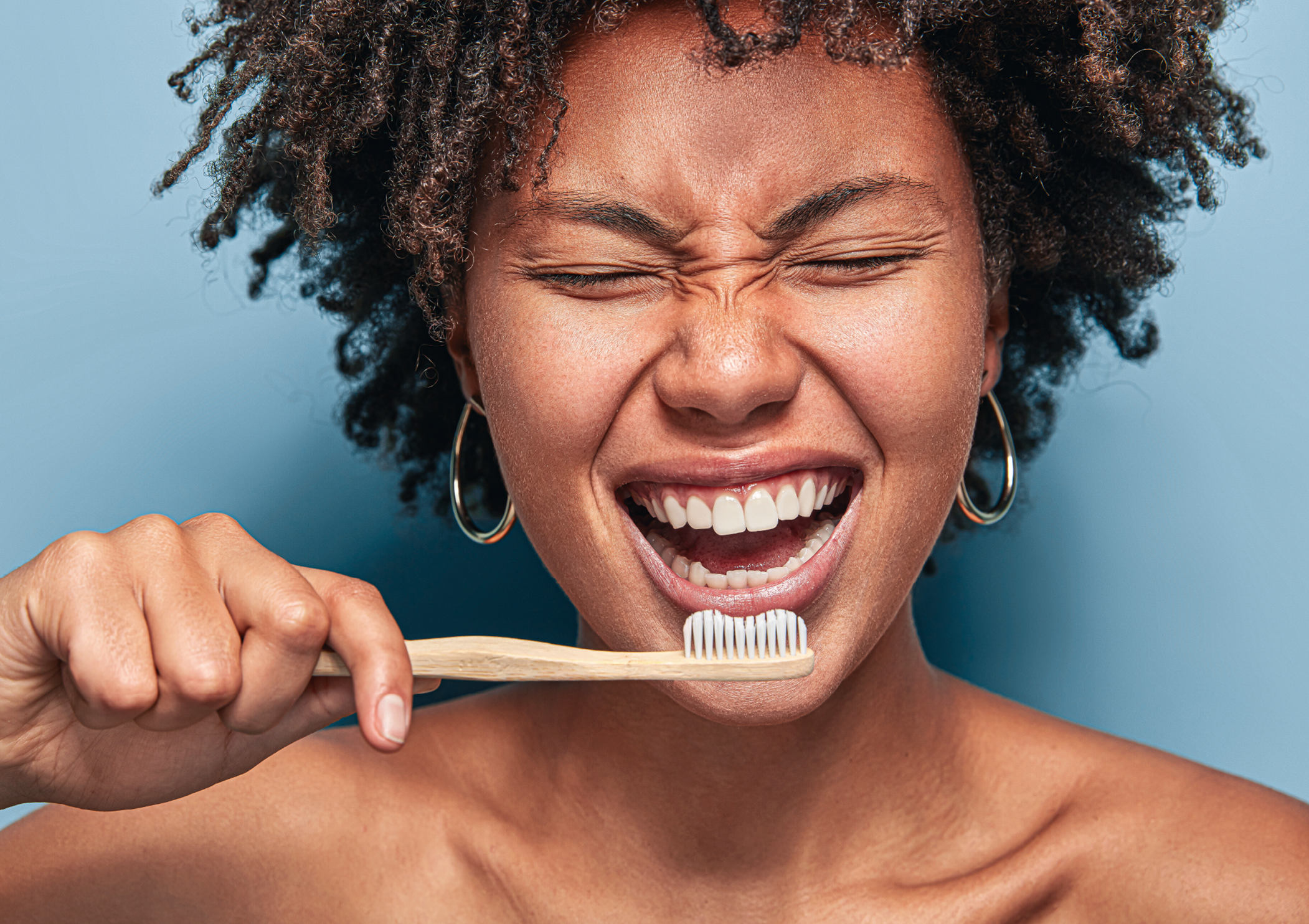 Person brushing teeth with joy